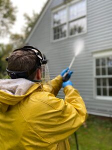 Man power washing house